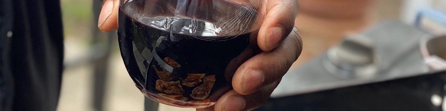 Hand holding glass of red wine for what to pair with bbq