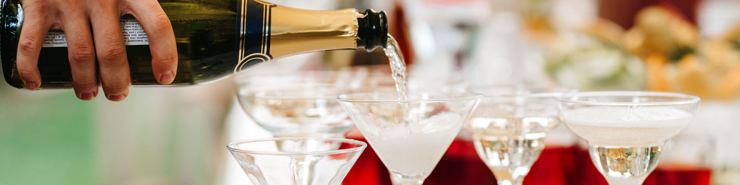 champagne being poured into champagne flutes on a tabletop