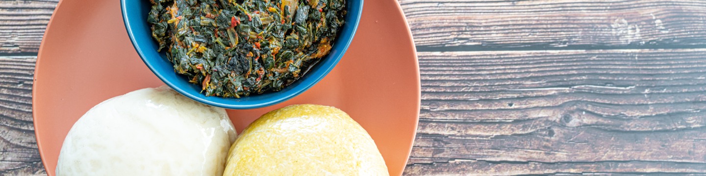 A bowl of Efo-riro and swallow dishes known as fufu on a plate. Spicy spinach stirred with meat. 